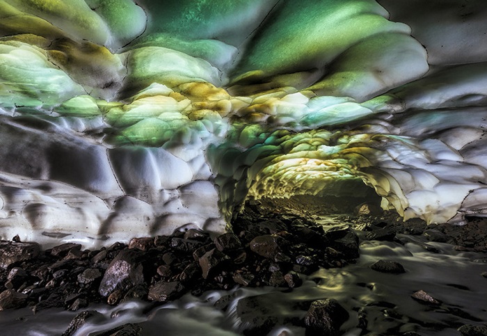 Пещера сформировавшаяся в жерле вулкана, где свет, проходящий через её свод, создает впечатляющую цветовую картину из зеленого, пурпурного и голубого цвета.